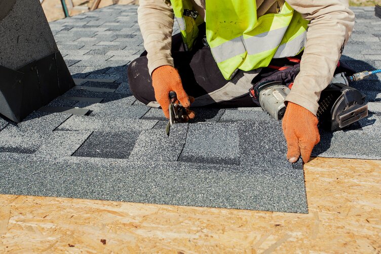Mann verlegt Asphaltschindeln