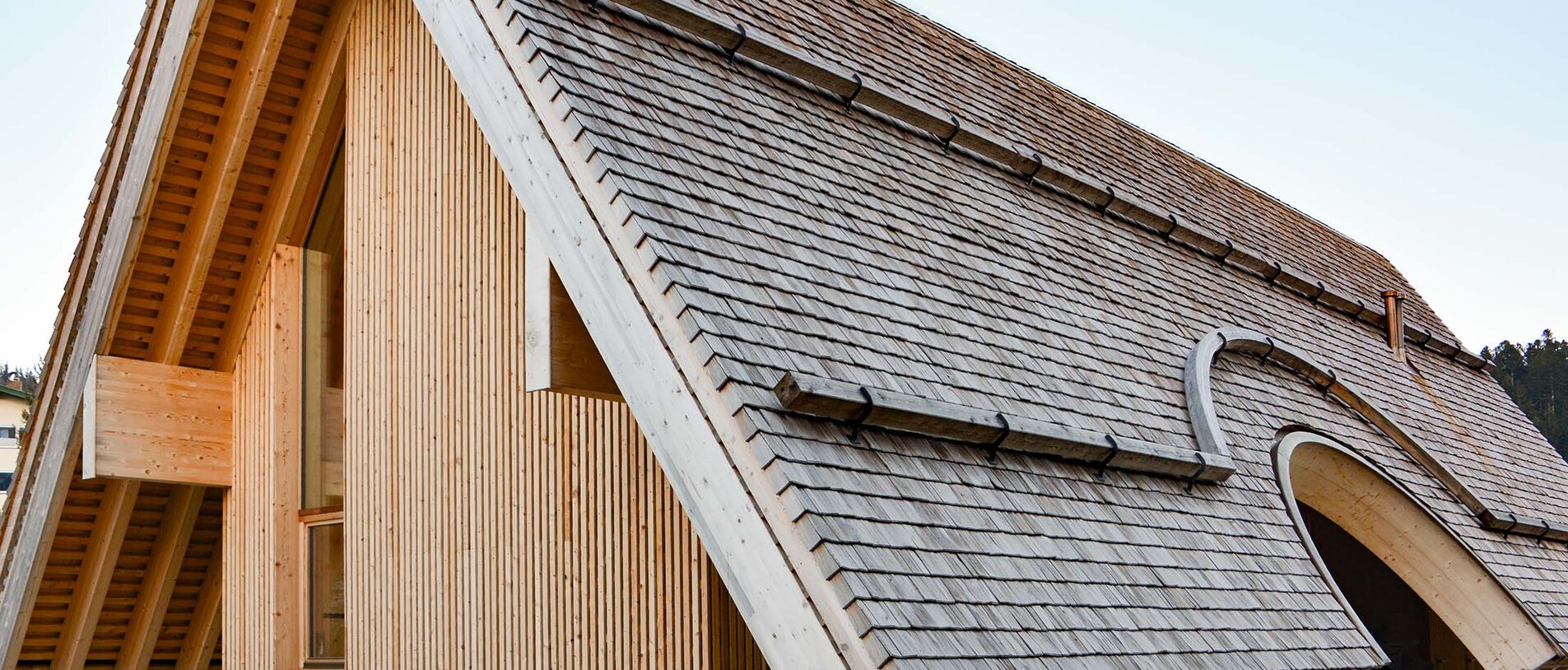 Bauernbogen Abtenau – seitliche Außenansicht mit geschwungenem Dach und Holzfassade, befestigt mit LIGNOLOC® Holznägeln von BECK
