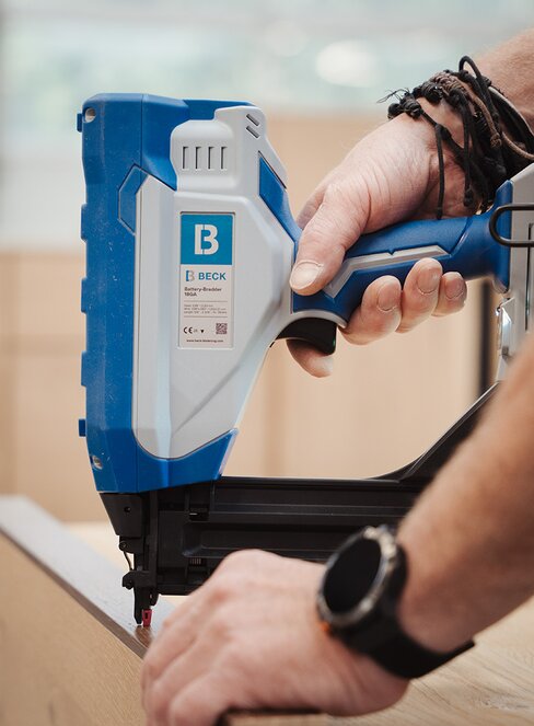 Handwerker arbeitet mit einem BECK Akku-Stauchkopfnagler an einer Holzoberfläche.