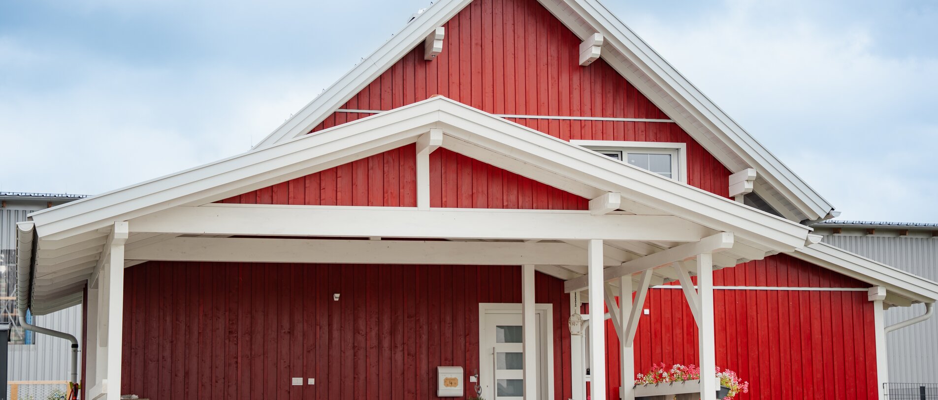 Norwegerhaus – Eingangsansicht | BECK Norwegerhaus – Eingangsbereich mit klassischer roter Holzfassade in Boden-Deckel-Schalung, befestigt mit LIGNOLOC® Holznägeln von BECK