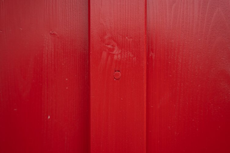 Norwegerhaus – Fassadendetail mit roter Boden-Deckel-Schalung, befestigt mit rot pigmentierten LIGNOLOC® Holznägeln von BECK