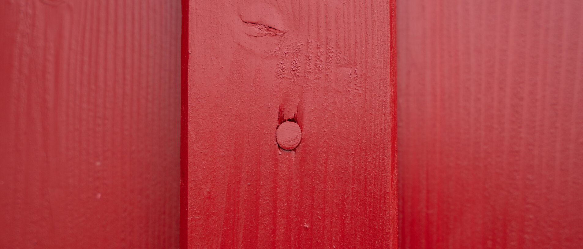 Norwegerhaus – Fassadendetail LIGNOLOC® Nagelkopf | BECK Norwegerhaus – Detailaufnahme der roten Fassade mit sichtbarem LIGNOLOC® Holznagel von BECK