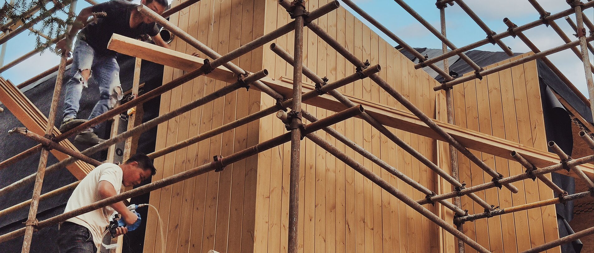 Workers fastening the wooden facade of a house using BECK LIGNOLOC® wooden nails