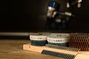 SCRAIL® nail screw fasteners by BECK on a wooden workbench, FASCO® pneumatic nailers by BECK in the background.
