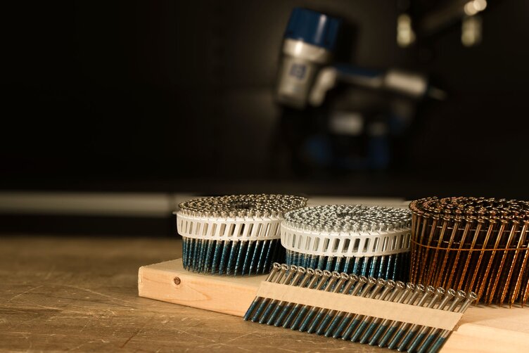 SCRAIL® nail screw fasteners by BECK on a wooden workbench, FASCO® pneumatic nailers by BECK in the background.