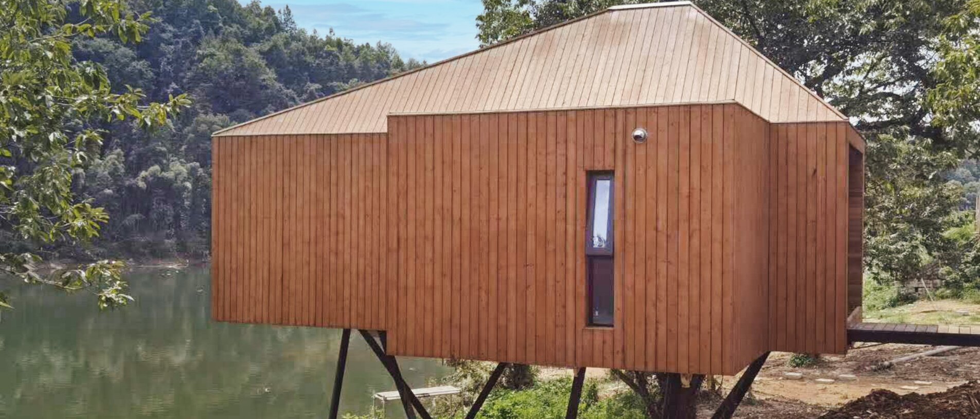 Exterior view of a modern timber house by the lake, constructed with BECK LIGNOLOC® wooden nails
